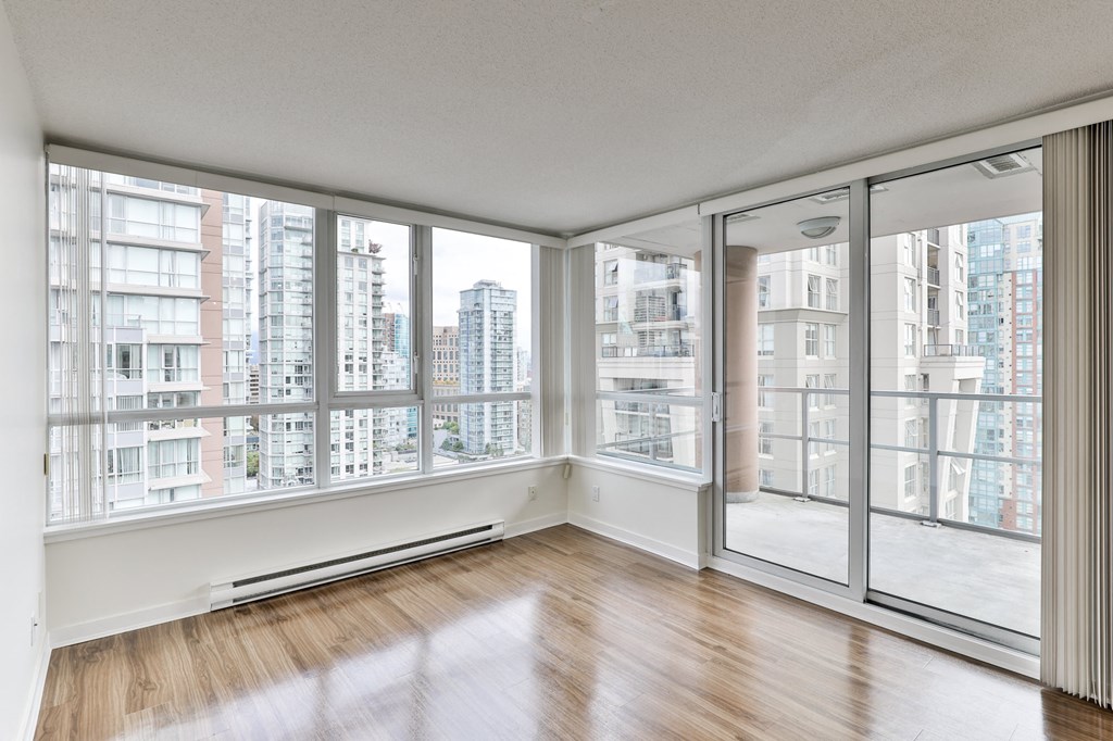 an empty living room with floor to ceiling windows and a city view