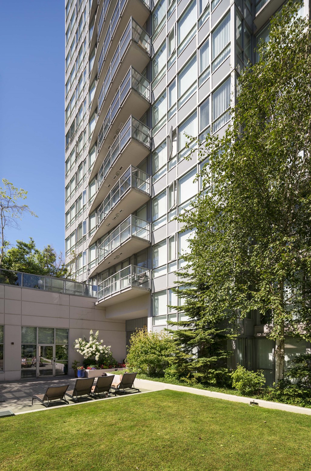 an outdoor patio with chairs in front of an apartment building