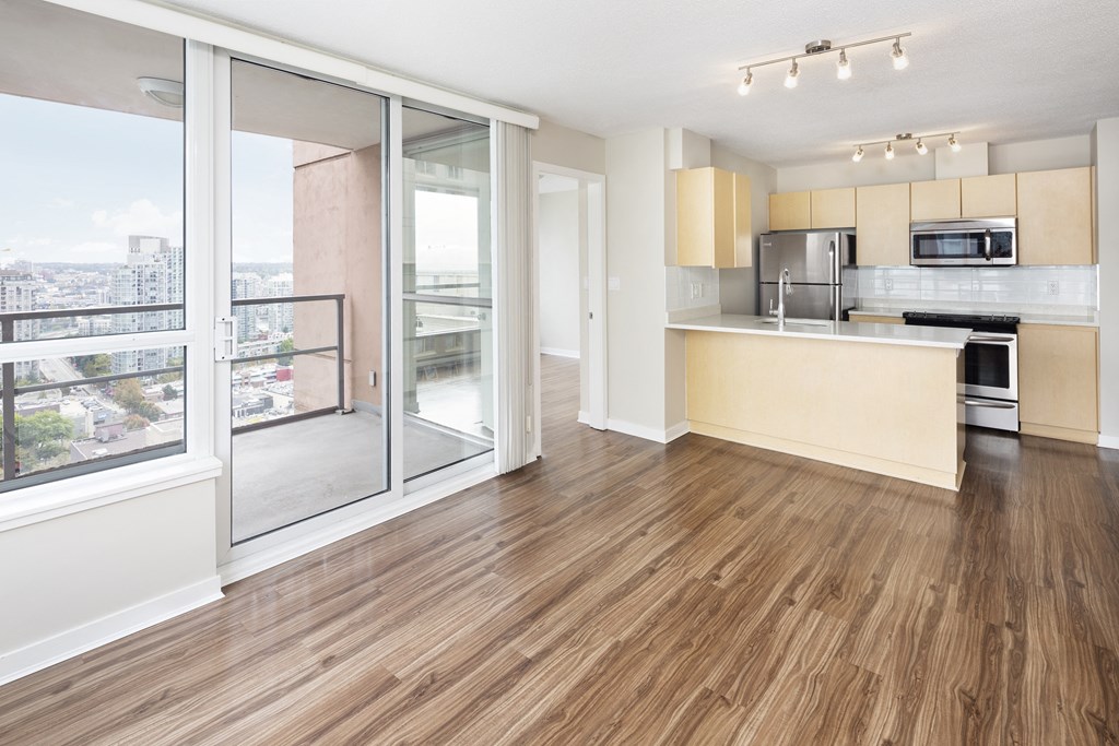 a living room with a kitchen and a large window