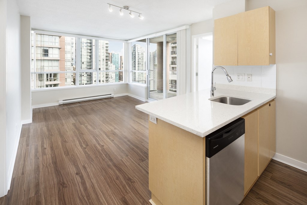 a living room and kitchen with a large window and a sink