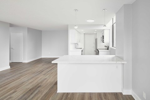 an open kitchen and living room with a white counter top