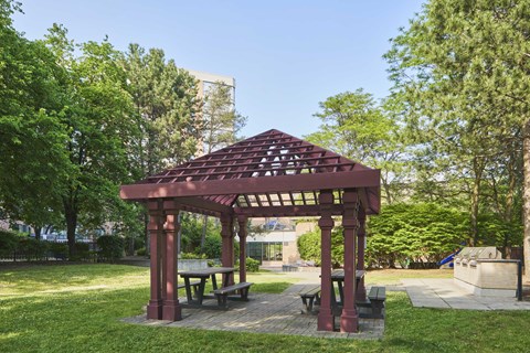 a picnic area with a wooden gazebo and benches