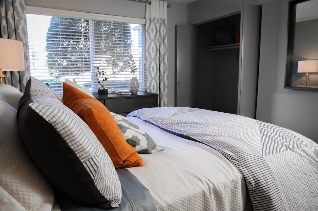 a bedroom with a bed with pillows and a window