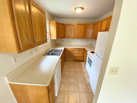 a kitchen with white appliances and wooden cabinets