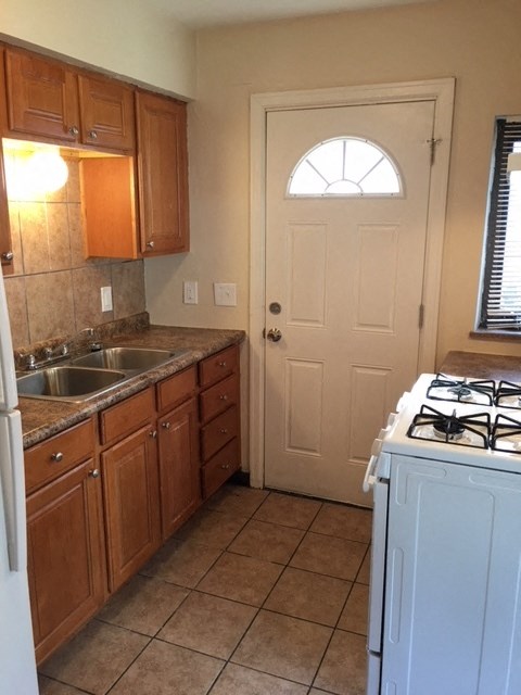 a kitchen with a stove and sink and a door