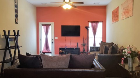 an orange walled living room with a couch and a tv