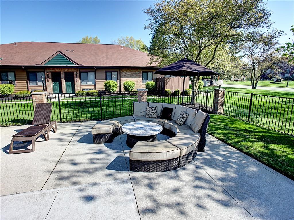 a patio with a couch and a table in front of a house