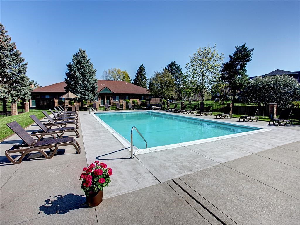a swimming pool with chaise lounge chairs