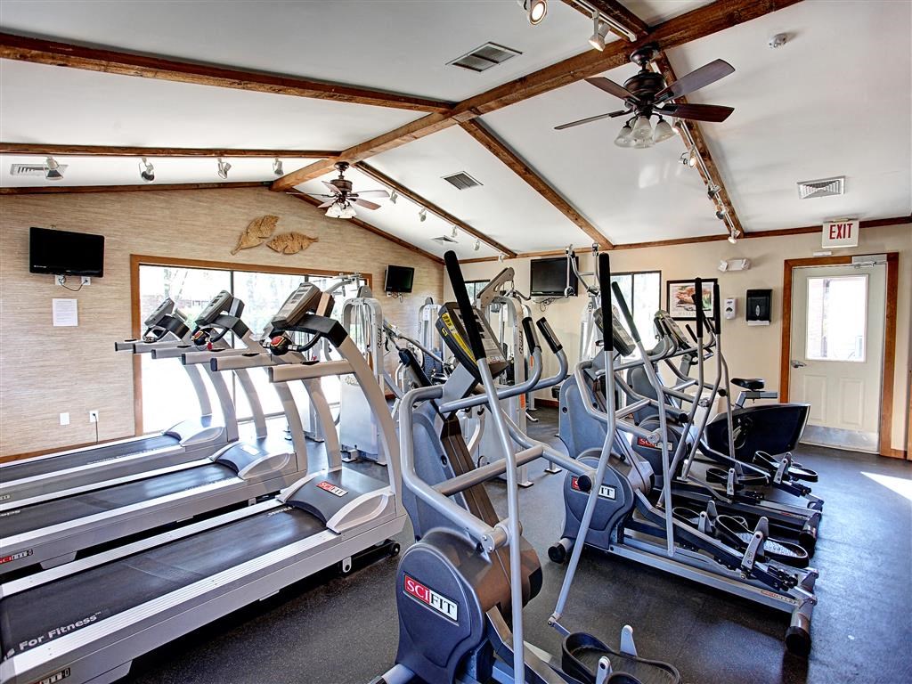 a gym with cardio equipment and a ceiling fan