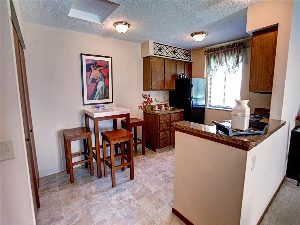 a kitchen with a bar and a table with chairs