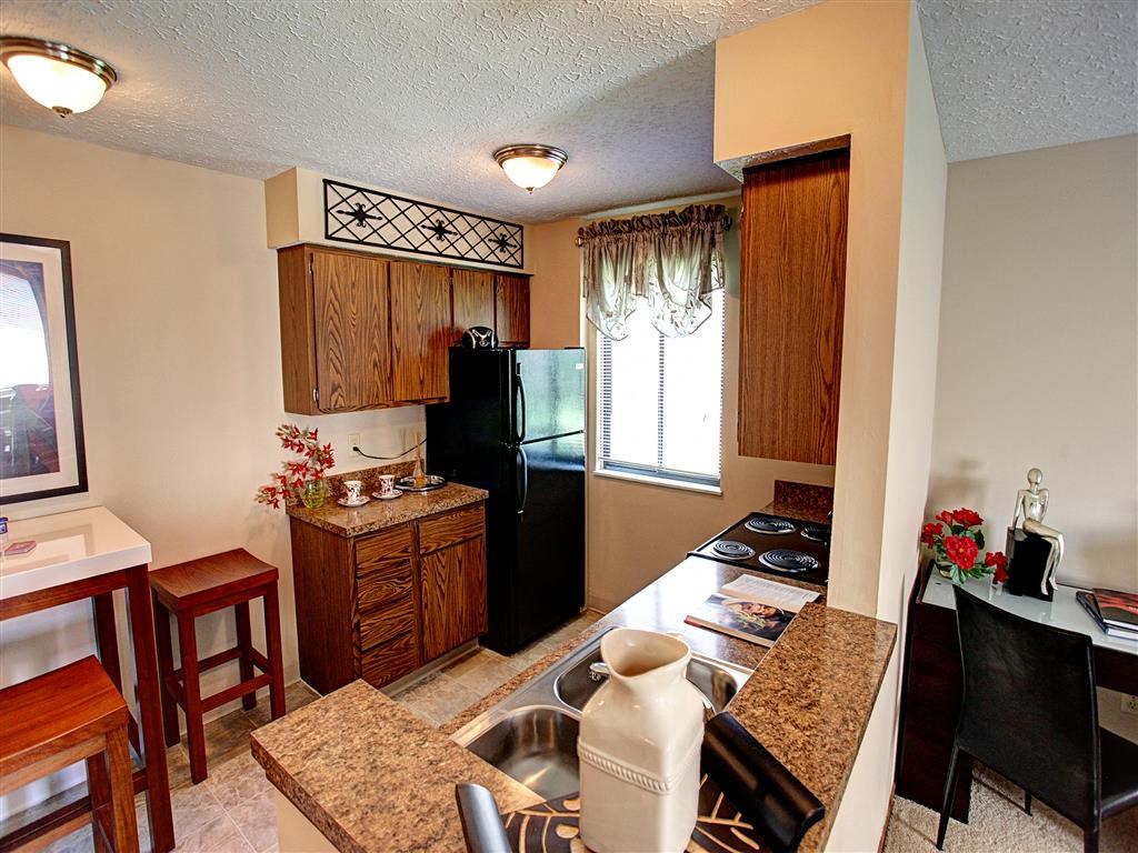 a kitchen with a sink and a black refrigerator