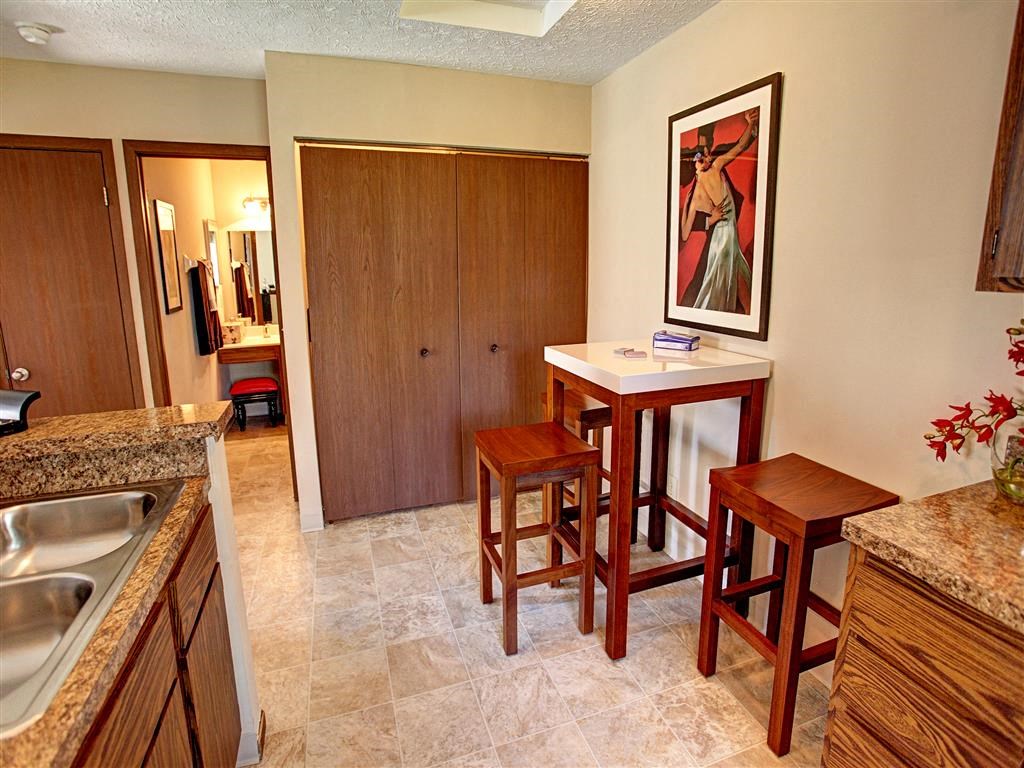 a kitchen with a bar with three stools
