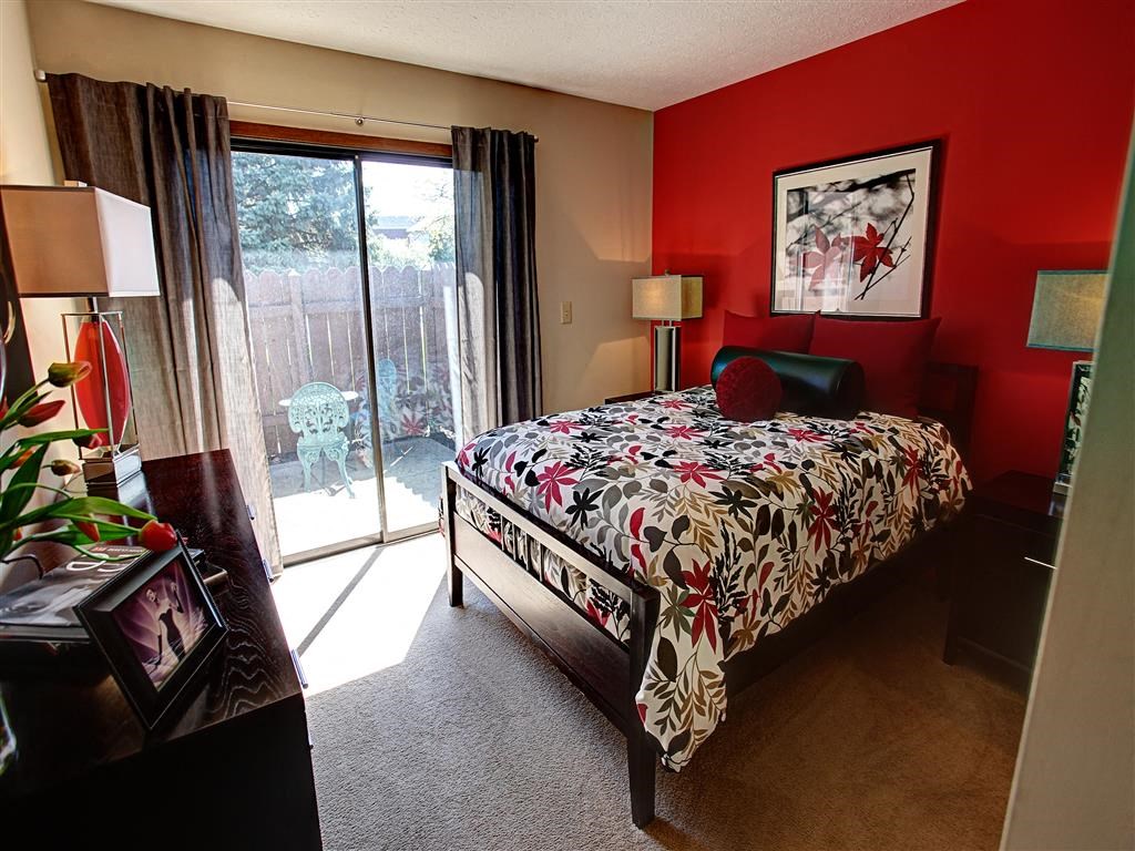 a bedroom with a bed and a sliding glass door