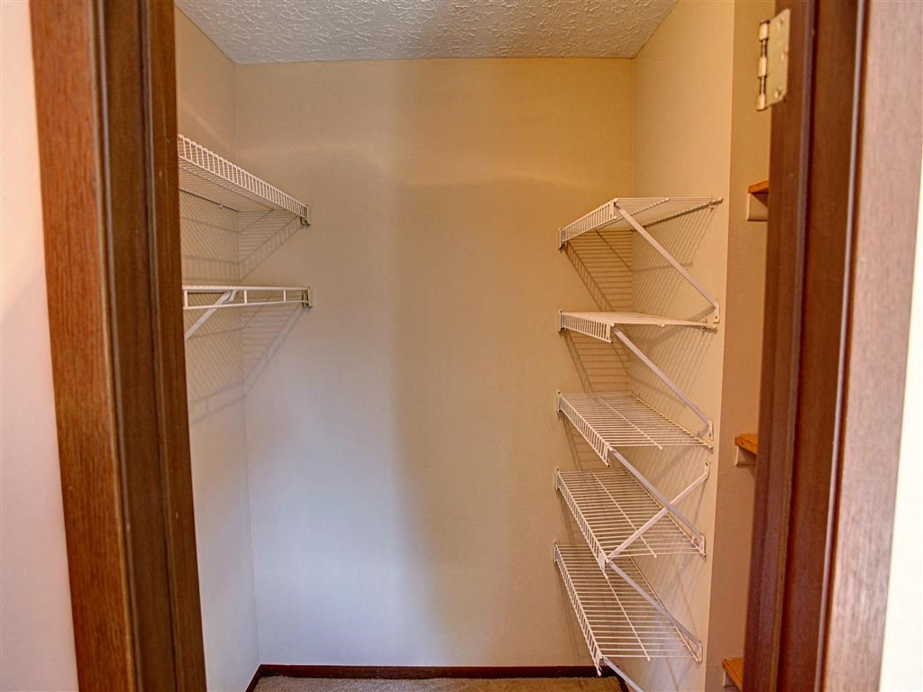 a closet with white shelves and