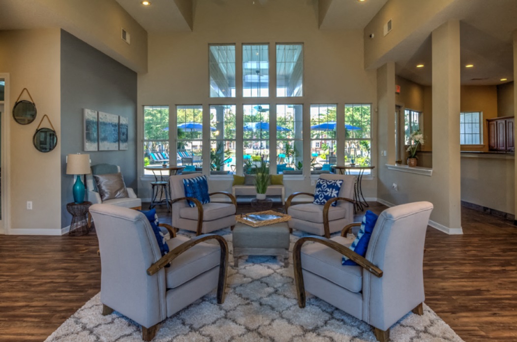 a living room with couches and chairs and a large window