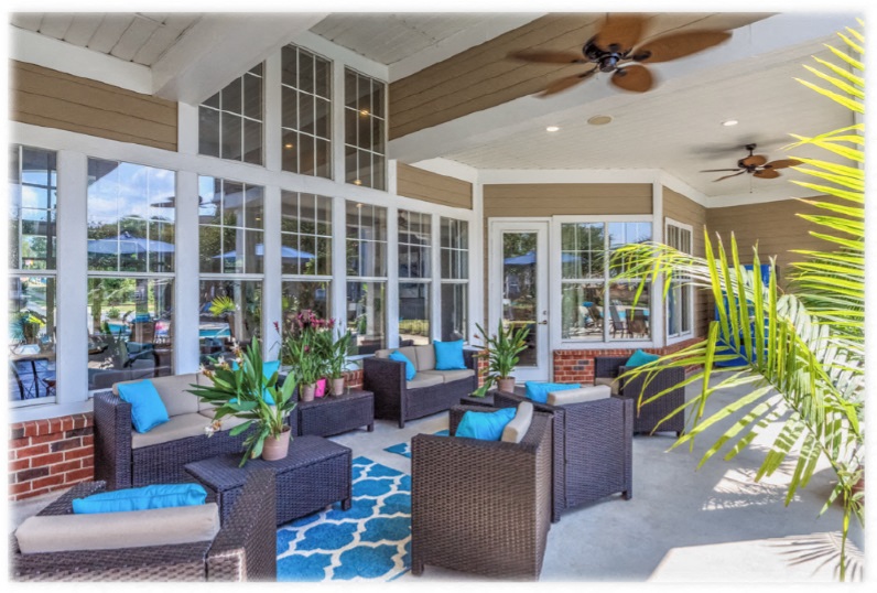 a covered patio with wicker furniture and windows