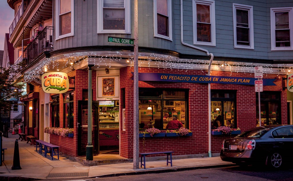 a restaurant on the corner of a city street at night