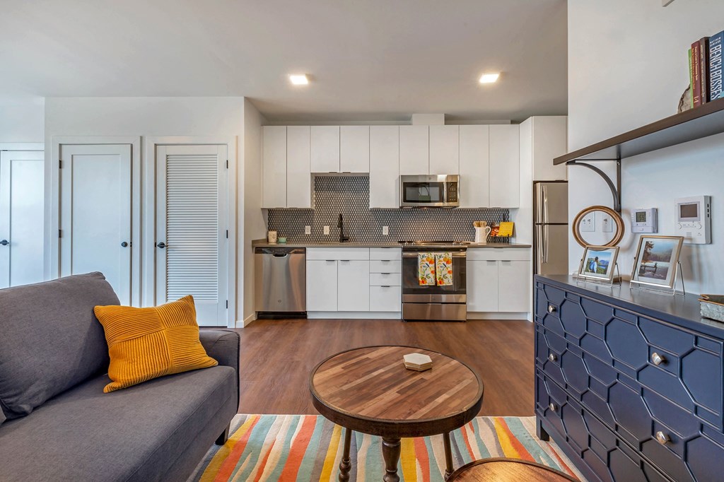 a living room with a couch and a kitchen