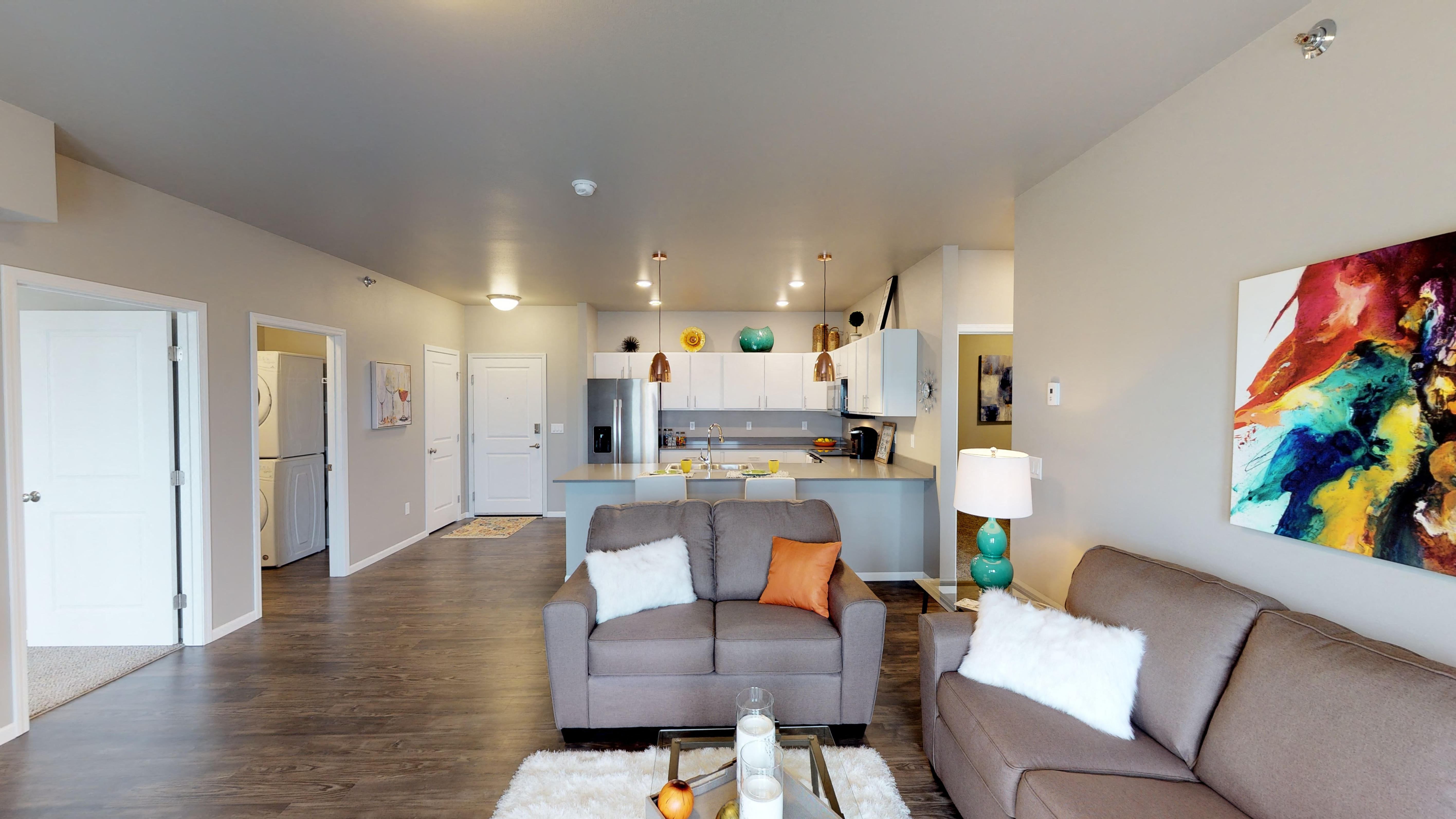 a living room with a couch and a chair and a kitchen