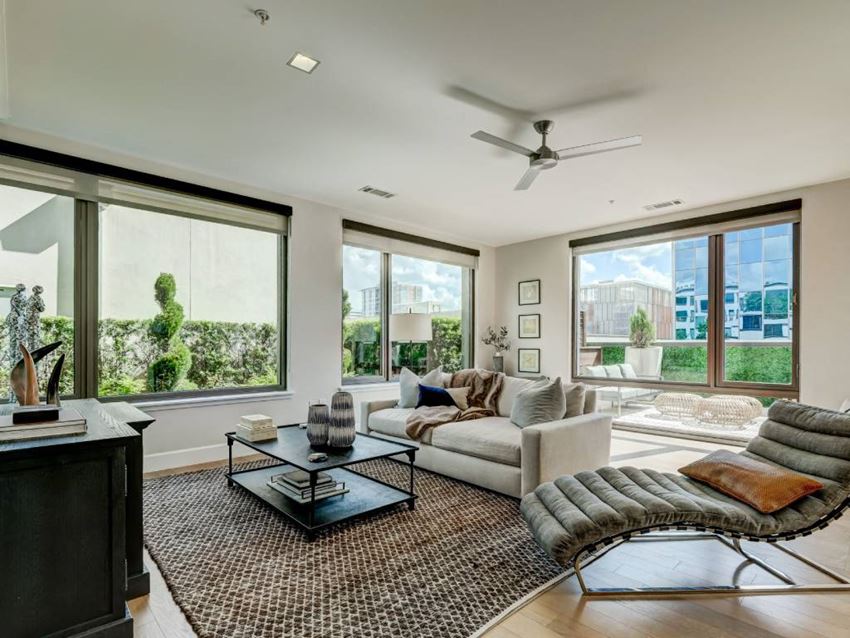 a living room with a couch and a coffee table and large windows