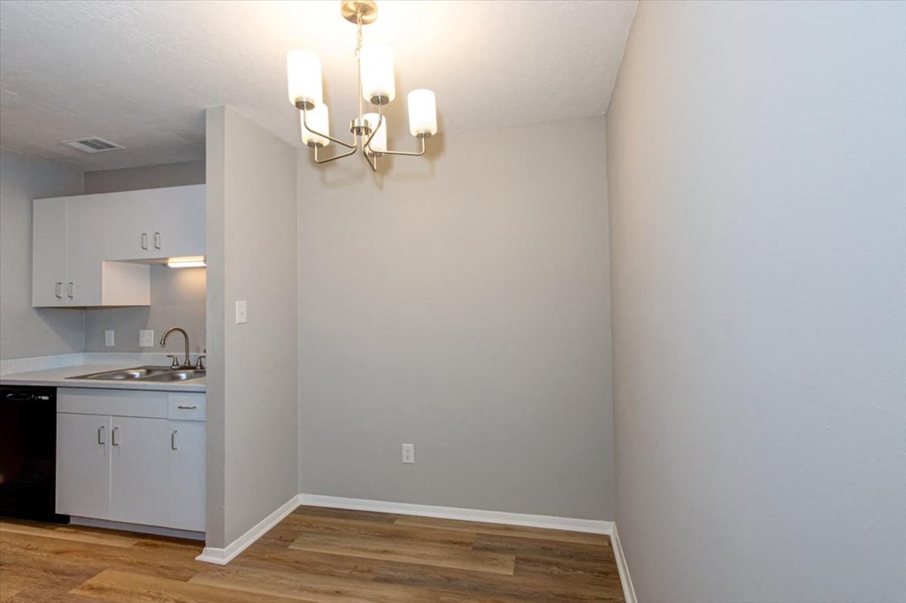 a kitchen with white cabinets and a wood floor