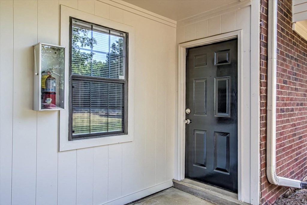 the front door of a house with a black door and a window