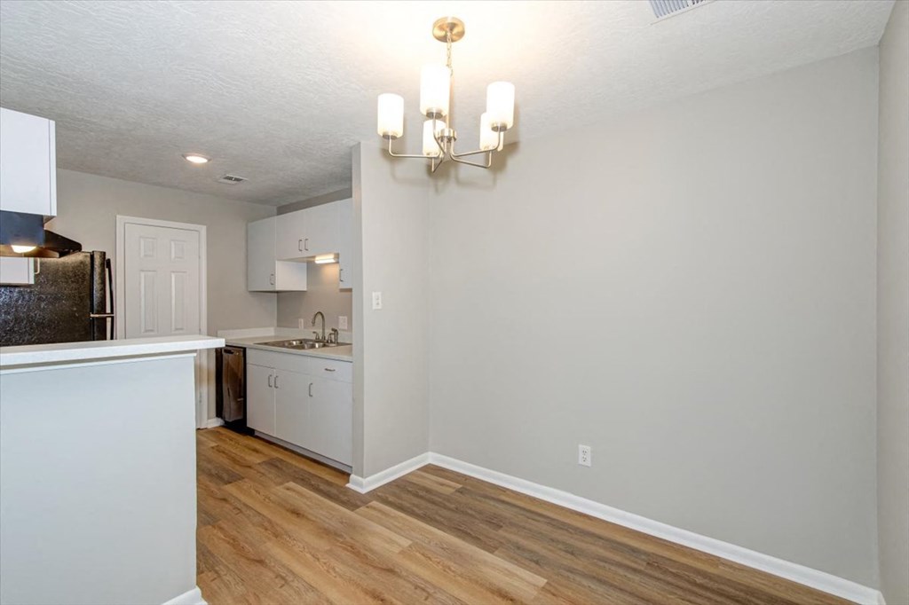 a kitchen and dining room with a wood floor and a chandelier