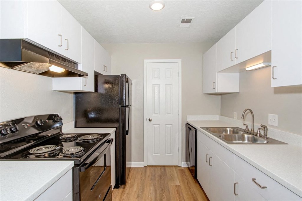a kitchen with a stove refrigerator and sink