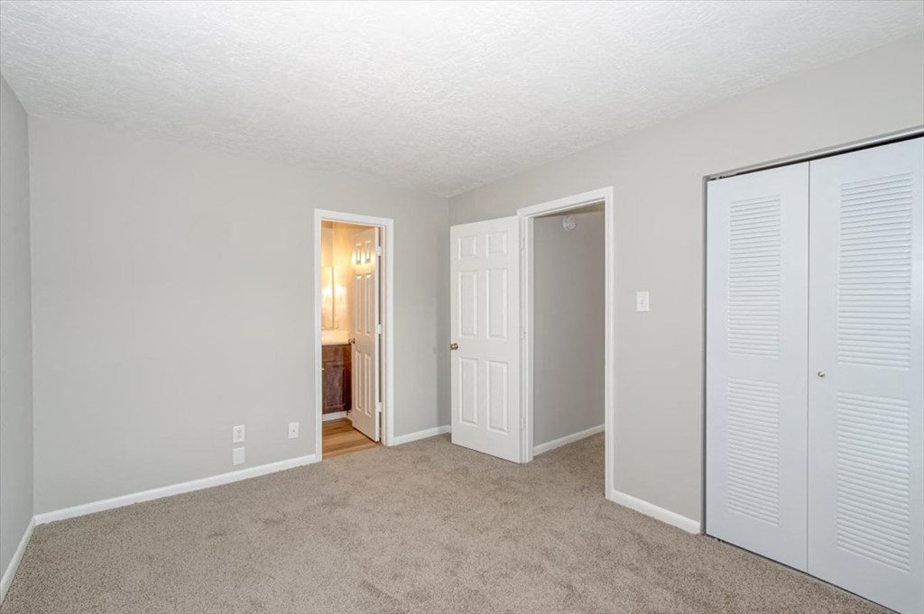 a bedroom with two closets and a door to a bathroom
