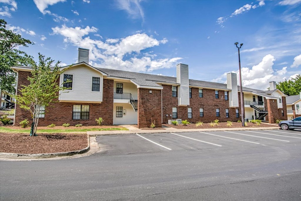 an empty parking lot in front of an apartment building