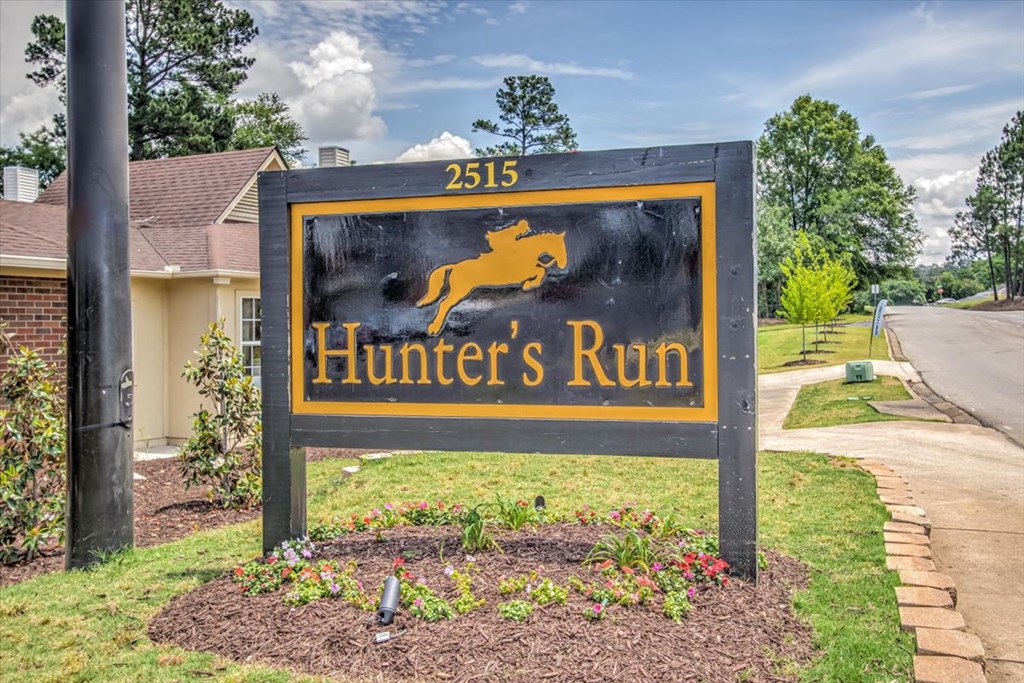 a sign for hunters run in front of a house