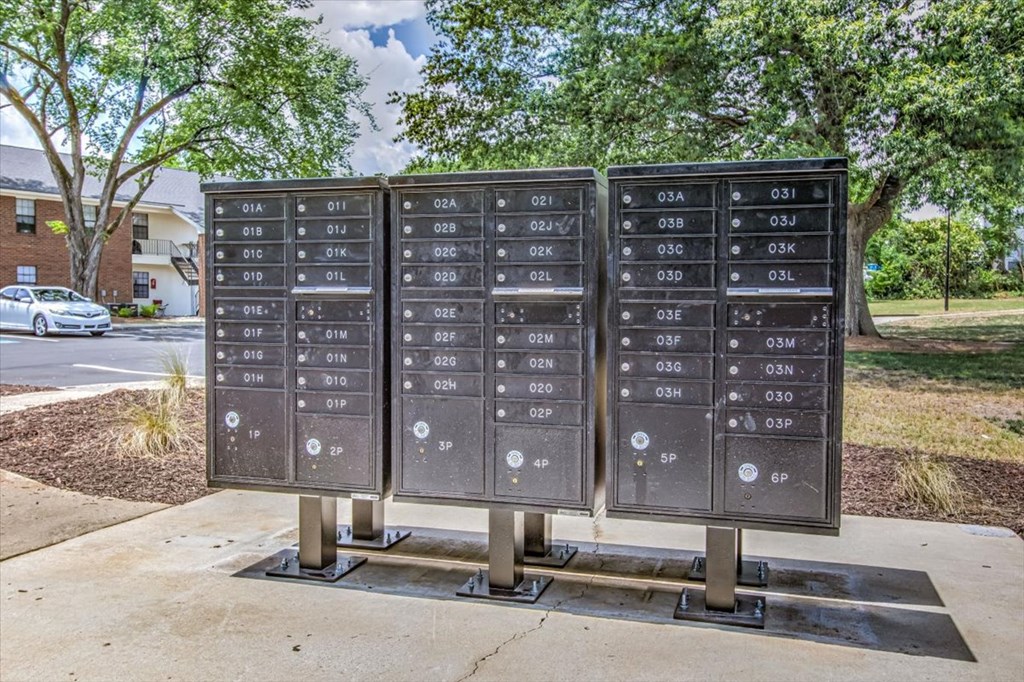 three metal boxes with numbers on them on a sidewalk
