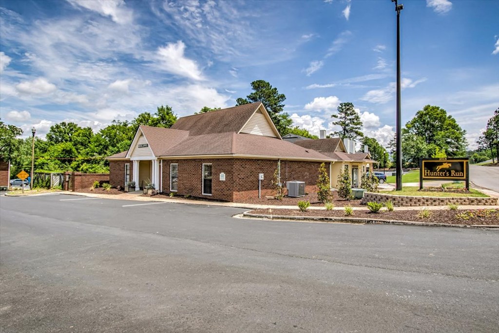 the front of a brick house with a road in front of it