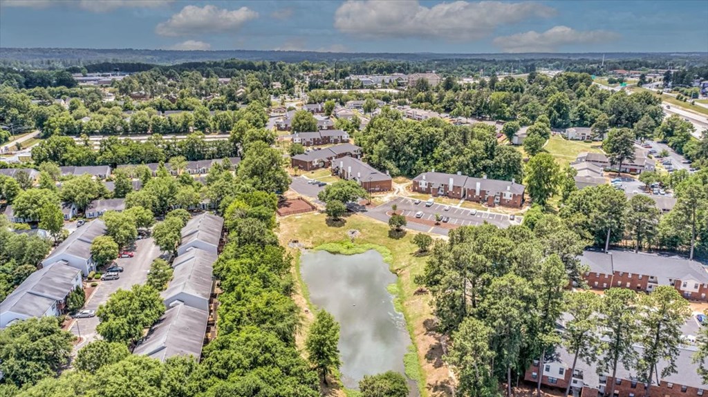 an aerial view of a neighborhood with houses and a pond