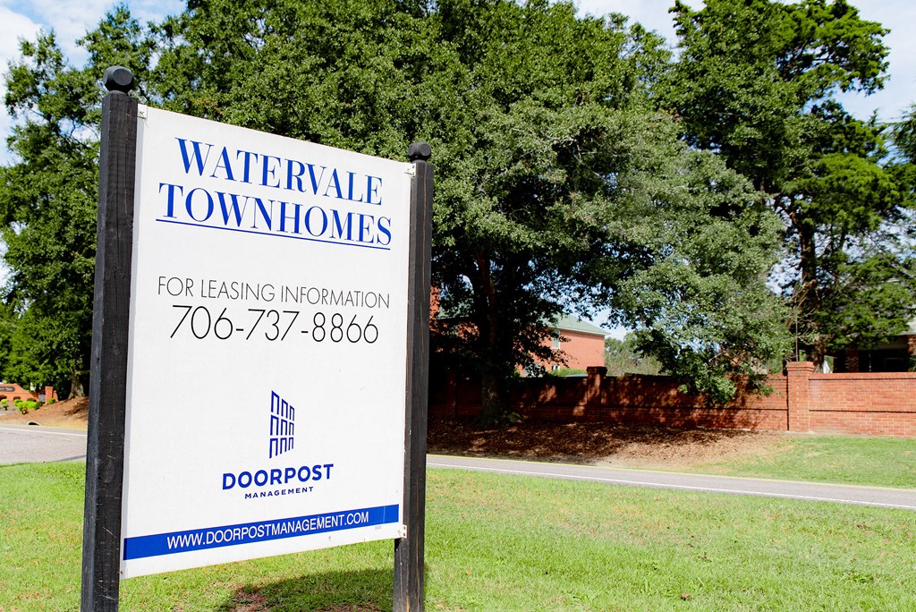 a sign for waterdale tow homes in front of a tree