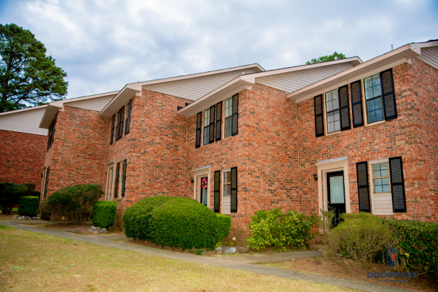 the front of a brick building with a cloudy sky in the background