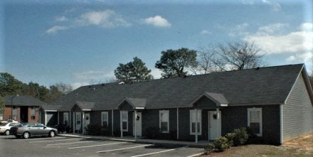 a row of houses with cars parked in a parking lot