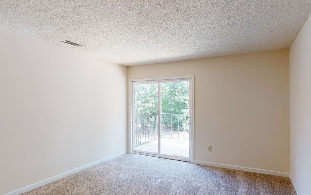 an empty living room with a door to a patio