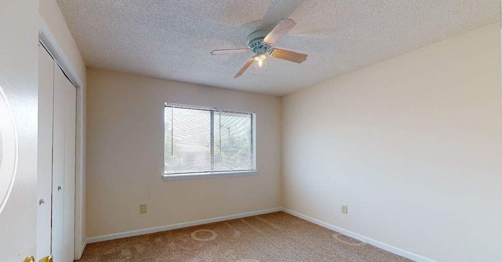 a bedroom with a ceiling fan and a window