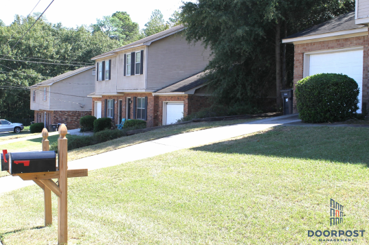 a yard with a mailbox in front of a house