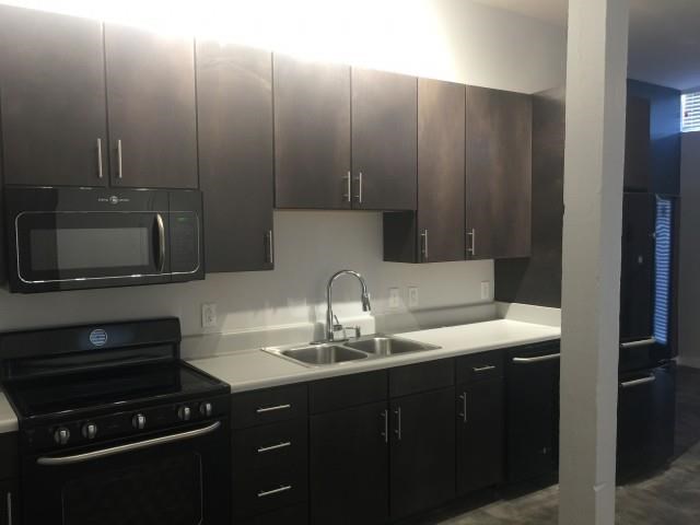 a kitchen with a sink and a stove and a microwave