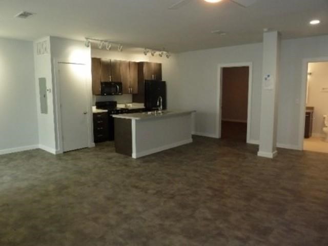 an empty room with a kitchen and a living room