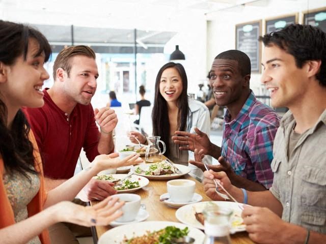a group of people sitting around a table eating food