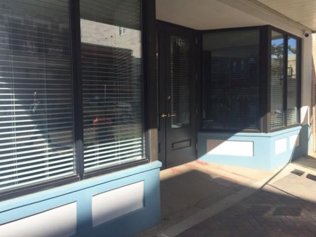 the front door of a building with blinds on the windows