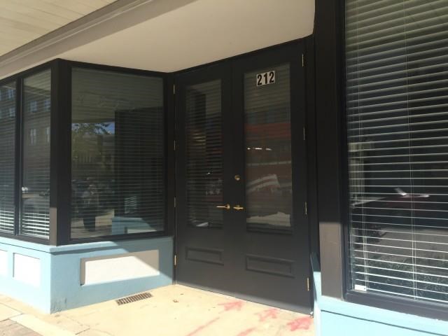 the front of a building with black doors and windows