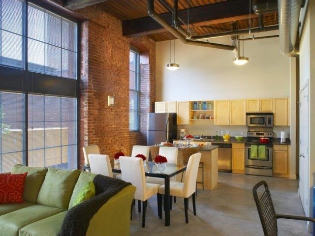 a living room with a table and chairs and a kitchen