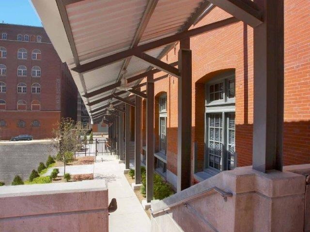 a brick building with awning and a sidewalk
