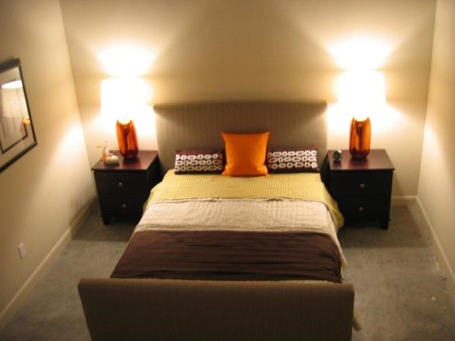 a small bedroom with a bed and two lamps