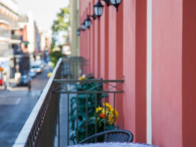 a balcony with tables and chairs and a street in the background