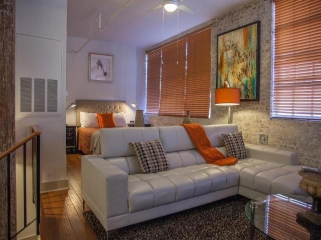 a living room with a white couch and a bed